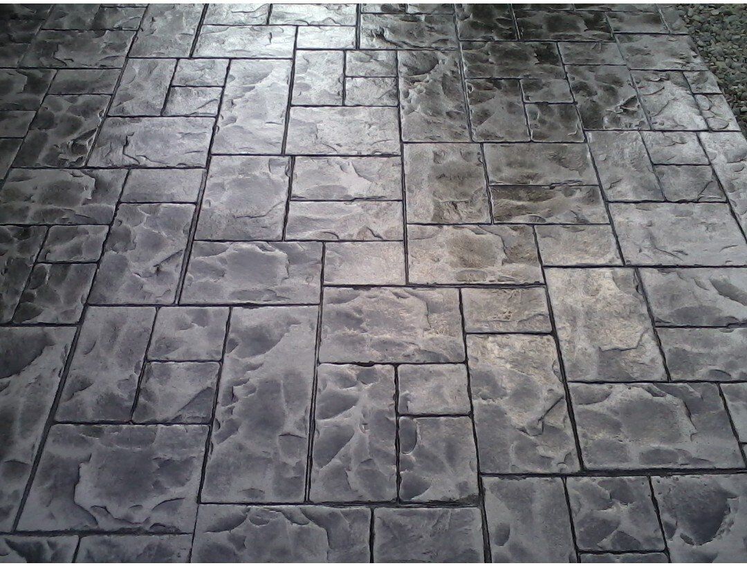 Gray stamped concrete walkway with a textured stone pattern